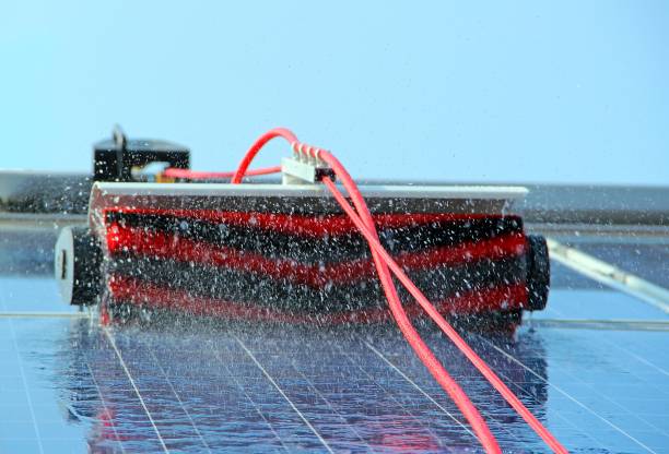 Cleaning solar panels with brush and water.